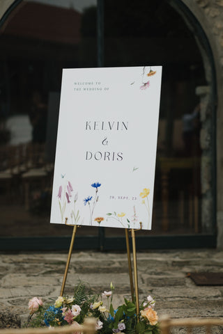 Welcome sign for wedding celebration with delicate flowers.