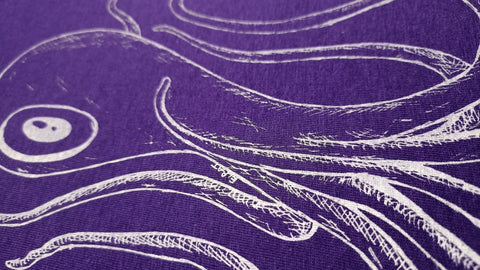 ElRat's Octoclops Purple Tee: Unique hand-drawn monster art in white print on a stylish purple tee. Edgy and eye-catching, a cinematic fashion statement by ElRat Designs