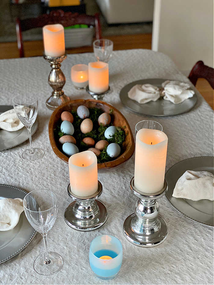 Table setting with blown eggs in shallow bowl and pillar candles