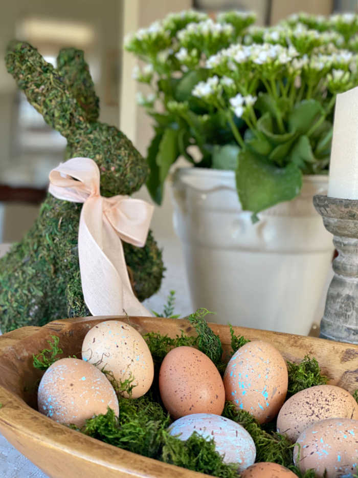 Blown eggs in a bowl with moss rabbit and potted plant