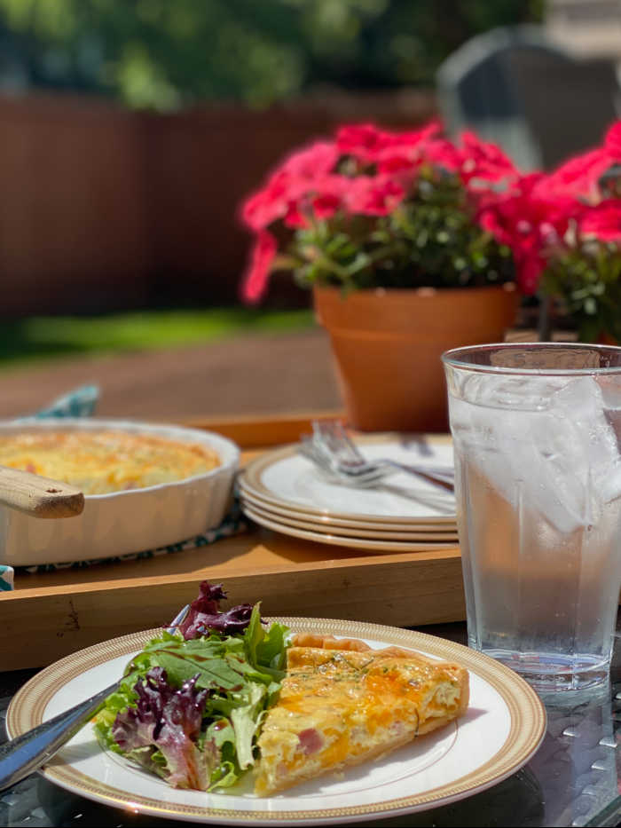 Quiche and iced water on table with flowers