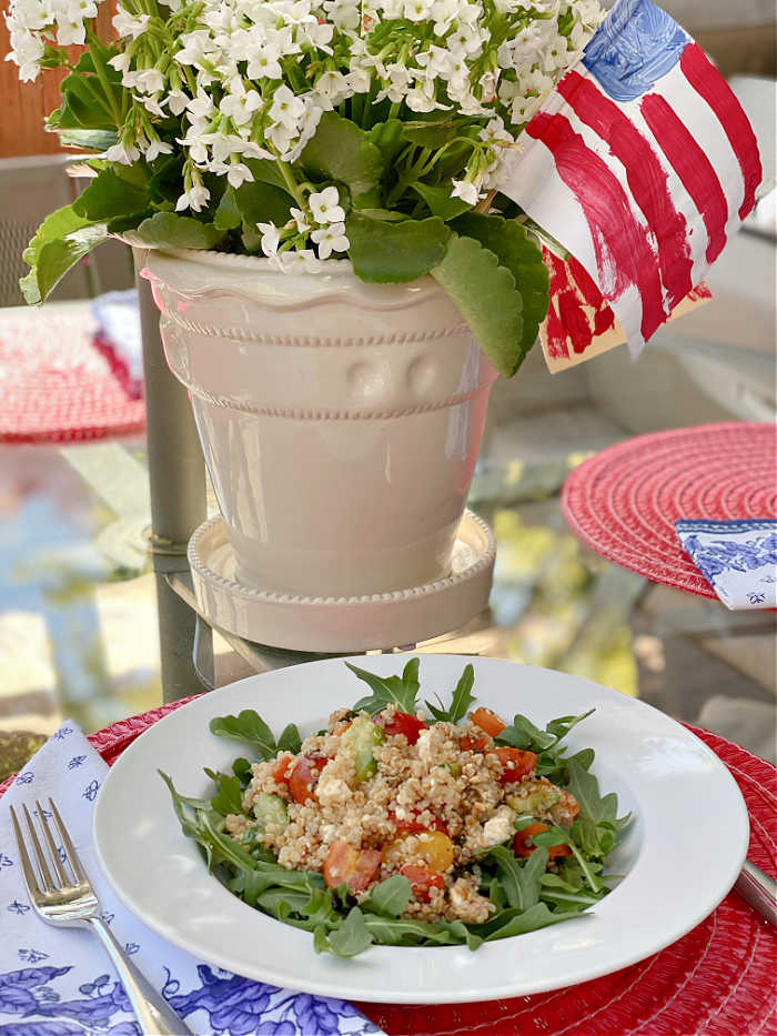 Quinoa salad in a bowl with a planter and American flag on a table