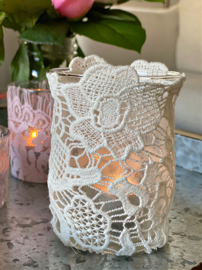 Learn how to easily make beautiful upcycled lace tea candle holders. With just a few materials you can create these lovely design elements that make super gifts too! #lace #craft #valentinesday #crafty