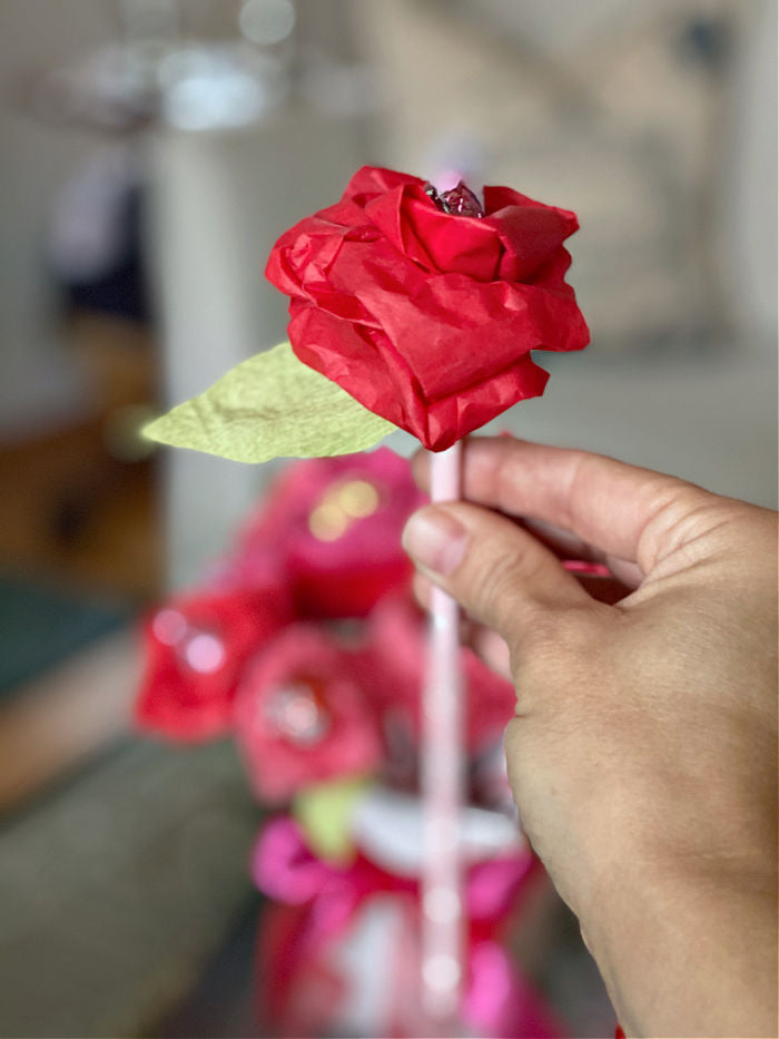 See how to easily make tissue paper rose for Valentine's Day. This easy and affordable craft is the perfect teacher, neighbor, classmate and galentine gift to treat this season! #valentine #valetinesday #roses #candy #crafts #tissuepapercrafts