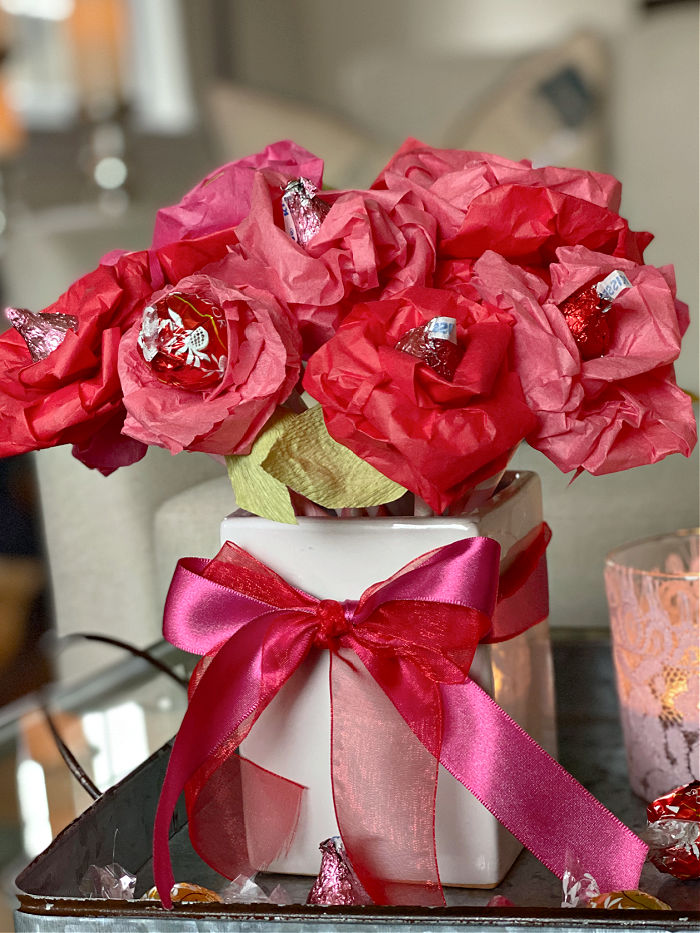 See how to easily make tissue paper rose for Valentine's Day. This easy and affordable craft is the perfect teacher, neighbor, classmate and galentine gift to treat this season! #valentine #valetinesday #roses #candy #crafts #tissuepapercrafts