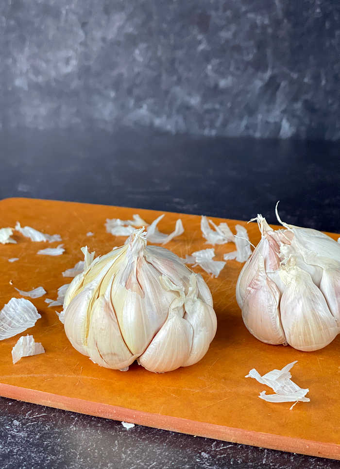 How to roast a garlic bulb in the oven recipe. This easy method delivers creamy and fragrant garlic every time! Serve roasted garlic on its own with crusty bread of mix into any number of delicious recipes. #garlic #roastedgarlic #secretsauce