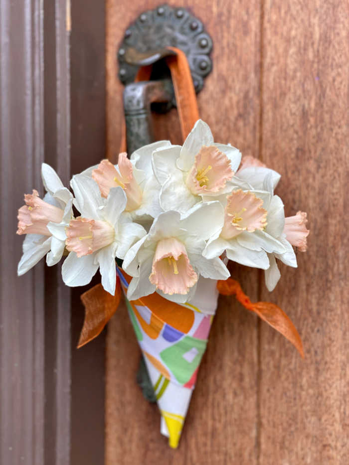Paper cone filled with flowers on doorknob