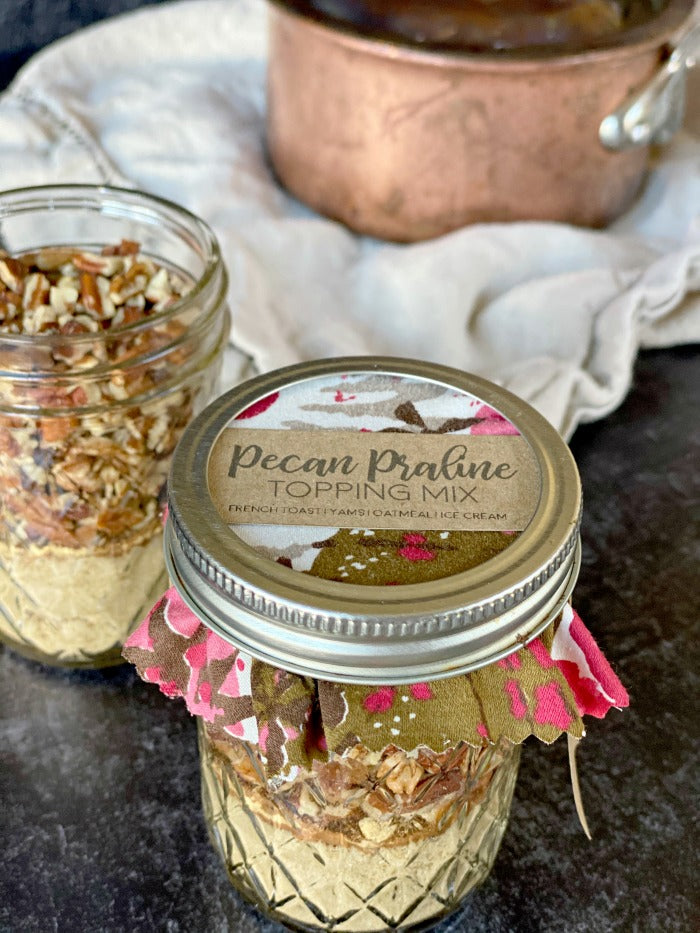 Pecan praline topping mix recipe and gift tag printable are all you need for a perfect holiday hostess gift or little treat for friends, family and neighbors. Just a few ingredients are required for this mason jar gift that can be paired with breakfast or dinner recipes. #masonjarrecipe #masonjargift #printable #hostessgift #holidaygift #praline #thanksgiving #holiday #holidayrecipe