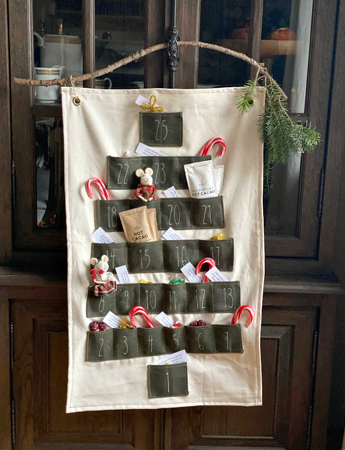 Holiday Advent calendar hanging from a branch on a cupboard