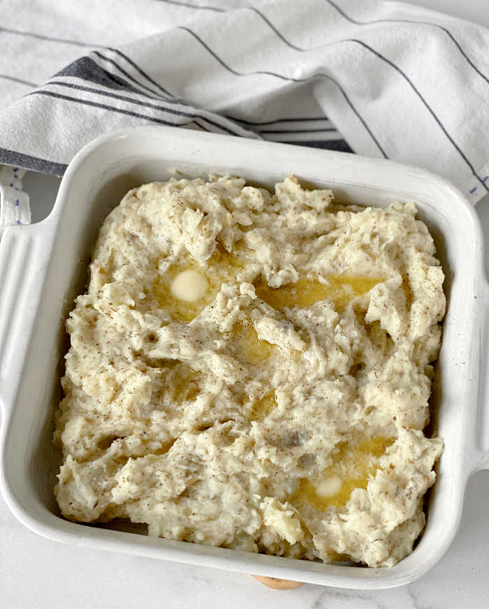Roasted garlic and herbed cheese mashed potatoes recipe. Try this rich and savory recipe to pair with all your favorite proteins. This recipe makes a love treat! #mashedpotatoes #herbedcheese #roastedgarlicrecipes #thanksgiving