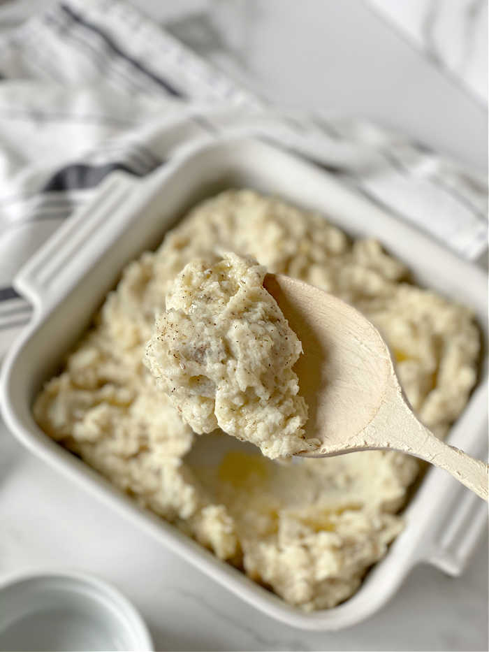 Roasted garlic and herbed cheese mashed potatoes recipe. Try this rich and savory recipe to pair with all your favorite proteins. This recipe makes a love treat! #mashedpotatoes #herbedcheese #roastedgarlicrecipes #thanksgiving