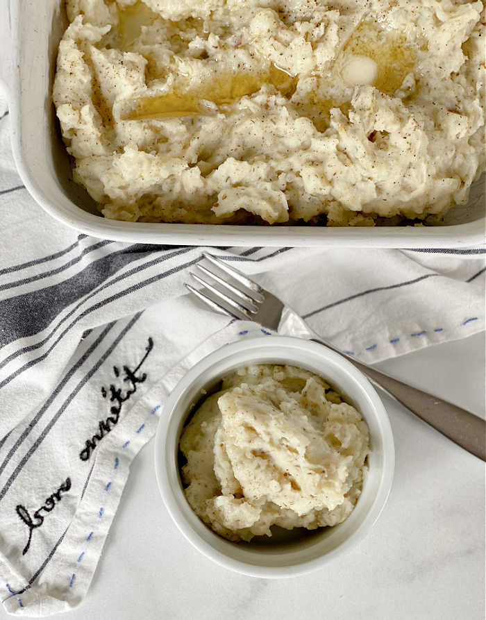 Roasted garlic and herbed cheese mashed potatoes recipe. Try this rich and savory recipe to pair with all your favorite proteins. This recipe makes a love treat! #mashedpotatoes #herbedcheese #roastedgarlicrecipes #thanksgiving