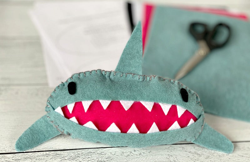 Sew easy shark tooth fairy pillow is the perfect project for little hands. Try this tooth fairy pillow with kids who are learning to sew. Or bypass needle and thread and simply use a glue gun to complete! #toothfairy #kids #sewing #beginnersewing #embroidery #blanketstitch #craft #crafty #crafts #feltcrafts