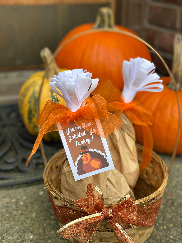 pumpkins and paper bag turkey leg in a woven basket