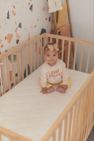 baby sitting up in 4-in-1-crib