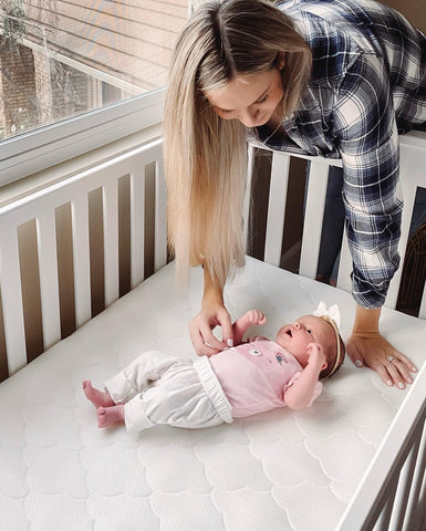 Mom putting baby down to sleep