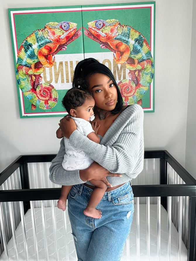 Mom holding baby in iguana themed nursery