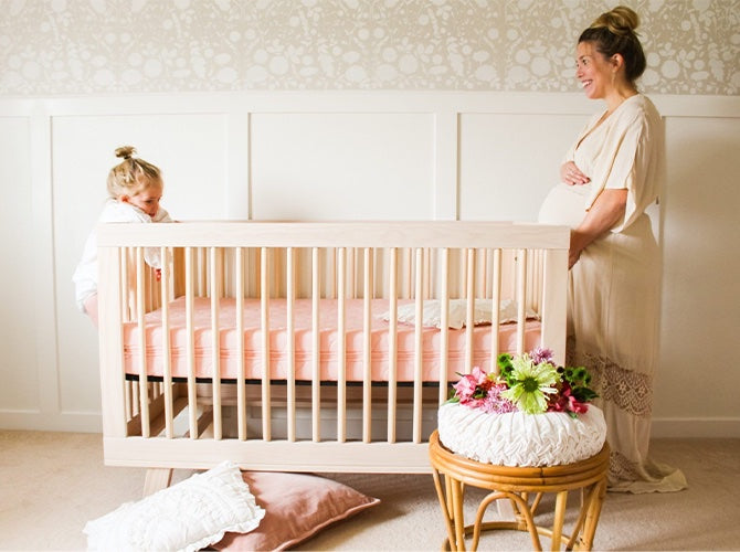 pregnant mom and daughter in baby girl nursery