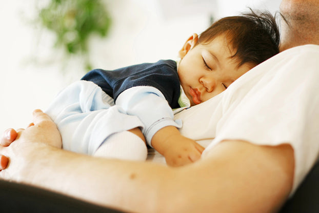 dad holding baby grunting in sleep