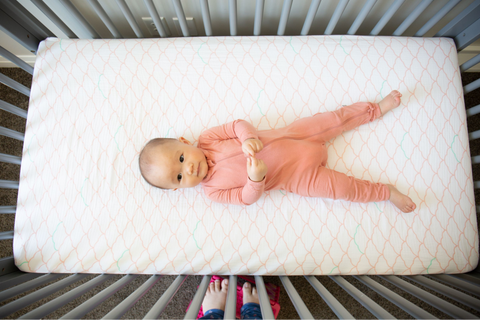 9 month old baby looking up from crib