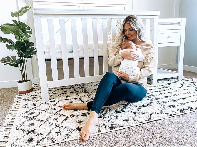 Mom holding baby in baby sleep sack