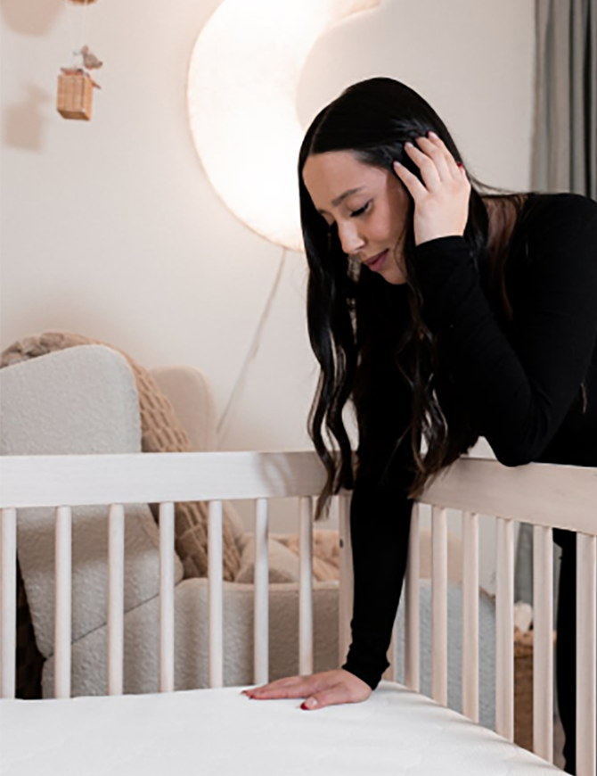 mom making crib up for baby