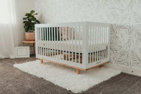 A white crib for twins in a nursery