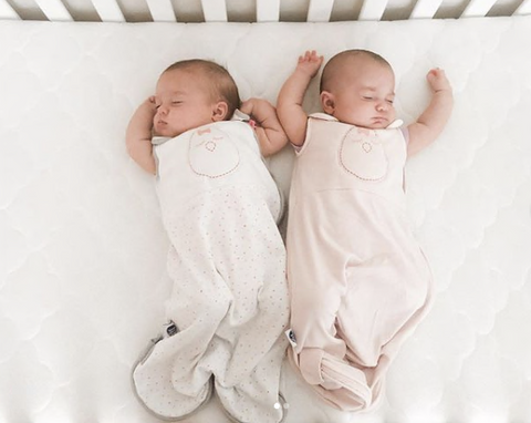 two babies sleeping in a crib for twins