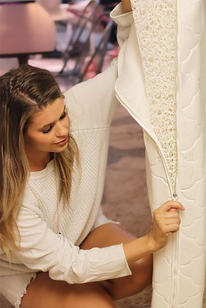 Mom taking cover off crib mattress to clean