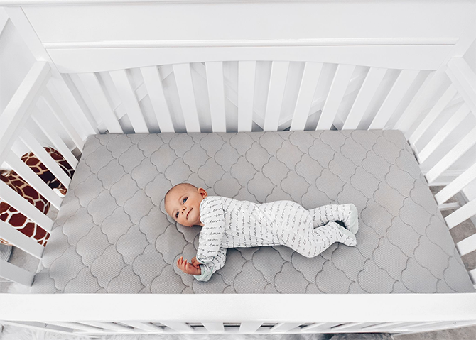 baby sleeping on crib mattress