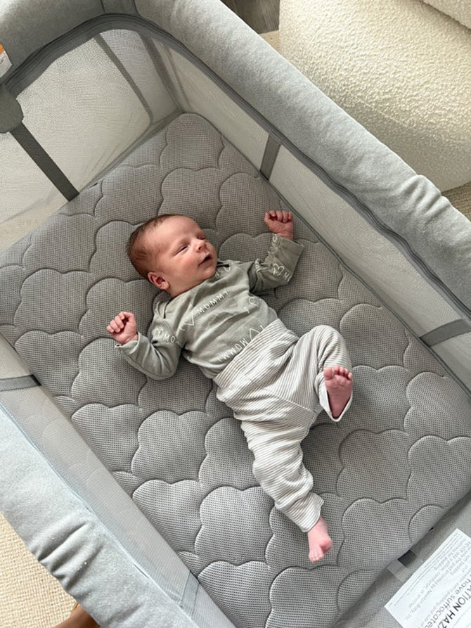 baby stretching in cute baby pajamas while in crib