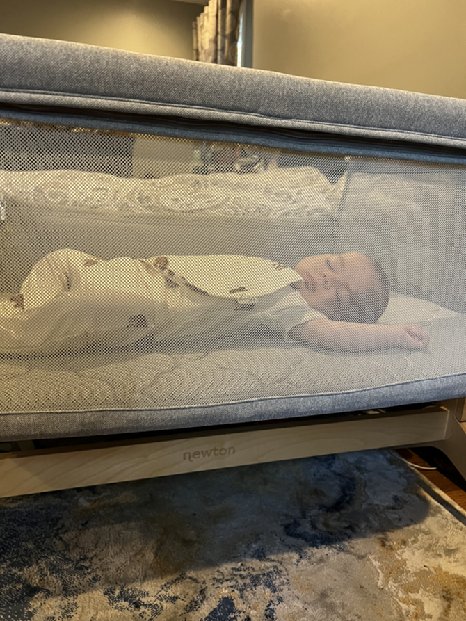 baby laying in a crib on its back