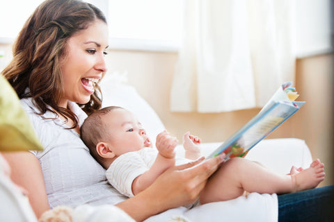 mom reading to baby in nursery