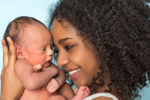 Mom holding newborn thinking about her baby nap schedule