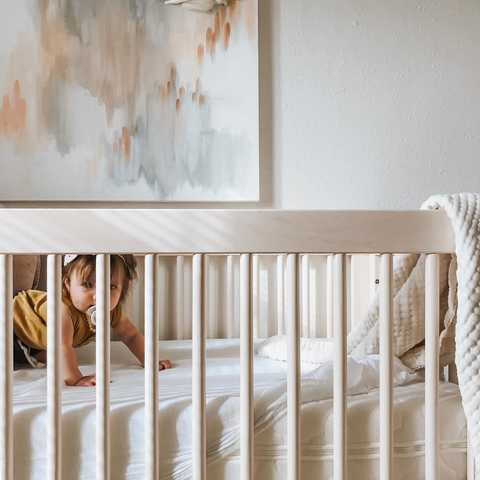 baby crawling in modern nursery crib