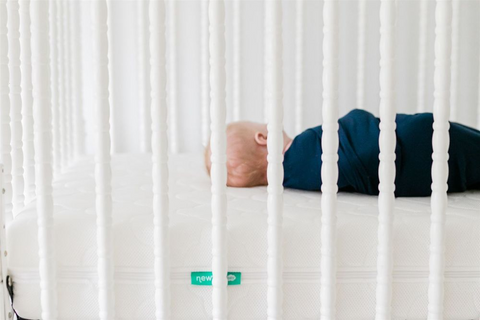 Baby sleeping on newton baby crib mattress