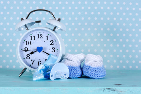 polka dot wall with alarm clock, baby booties, and pacifier 