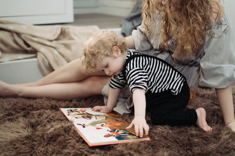 mom and toddler reading a book in the nursery