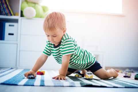 Kid playing on a rug in his playroom