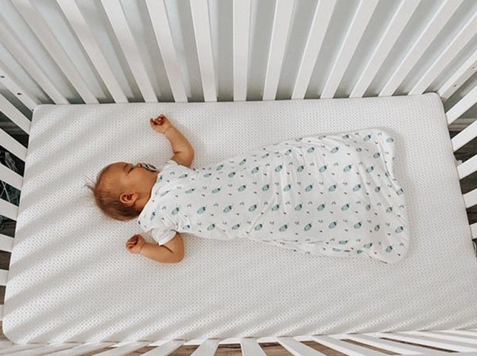 top view of newborn sleeping in crib