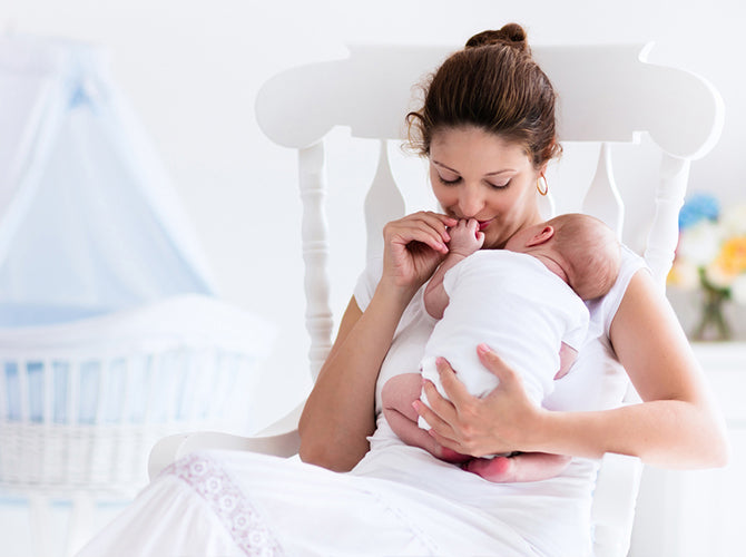 mom snuggling newborn knowing she has all the postpartum essentials