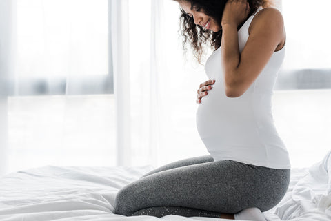 Woman on bed experiencing pregnancy brain