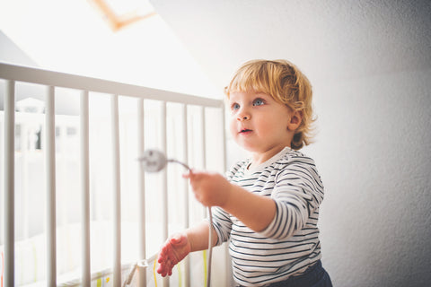 young boy near playing by a crib