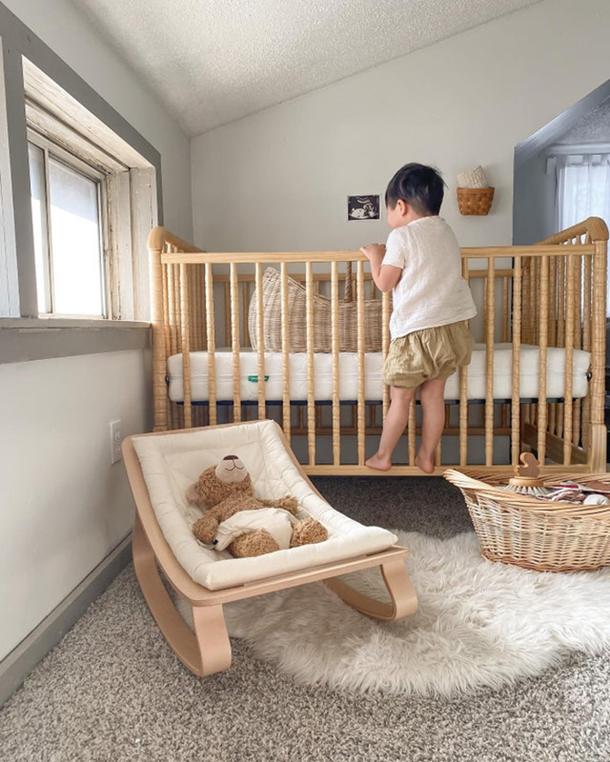 Young boy climbing into a crib