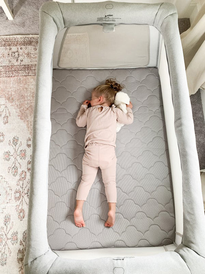 Toddler lying on stomach in a crib