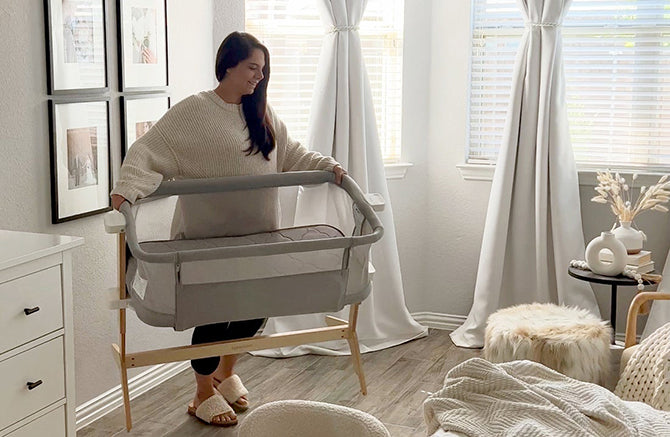 Mom carrying a travel bassinet