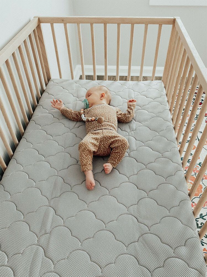 baby sleeping on back in crib