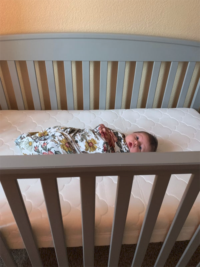 baby in a swaddle in crib