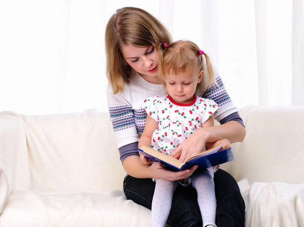 Mom reading to toddler as she learns when to transition to one nap