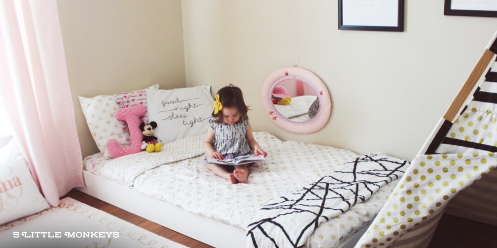 child sitting on montessori floor bed